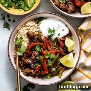 Rice bowl with ground beef fajita meat and bell peppers and onion.