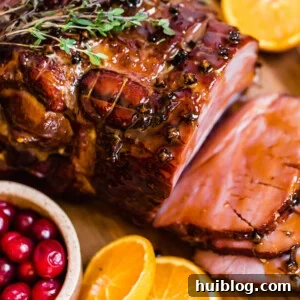 Slices of Christmas Ham on a Circular Wooden Surface with Assorted Fruits