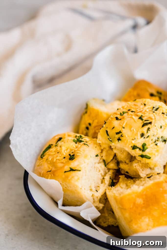 Soft Parmesan Dinner Rolls served in an elegant white dish, presented against a soft white towel, ready to be enjoyed.