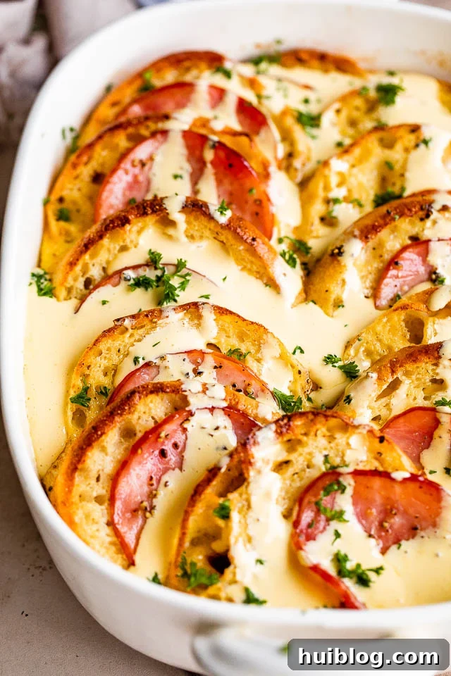 overhead shot of baked eggs benedict casserole topped with hollandaise sauce.