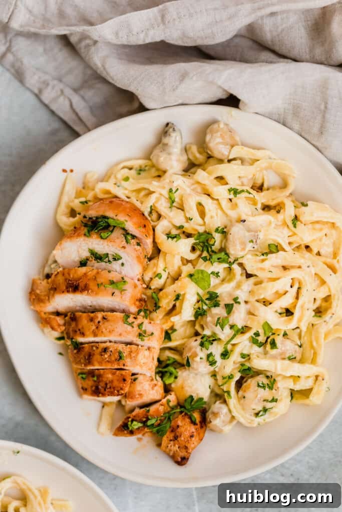 Velvety Chicken Fettuccine Alfredo 8 A Bowl of Creamy Fettuccine Alfredo with Mushrooms and Sliced Chicken Breast