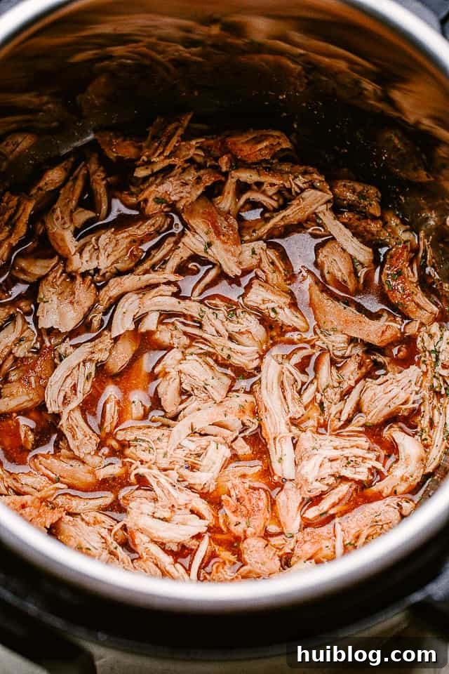 Shredded chicken put back into the honey garlic sauce in the Instant Pot.