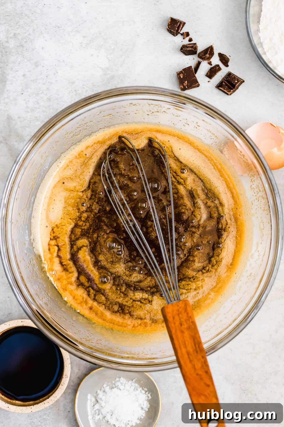 Decadent Homemade Fudge Brownies 5 Vanilla extract being mixed into a bowl with melted butter, sugars, and eggs for brownie batter