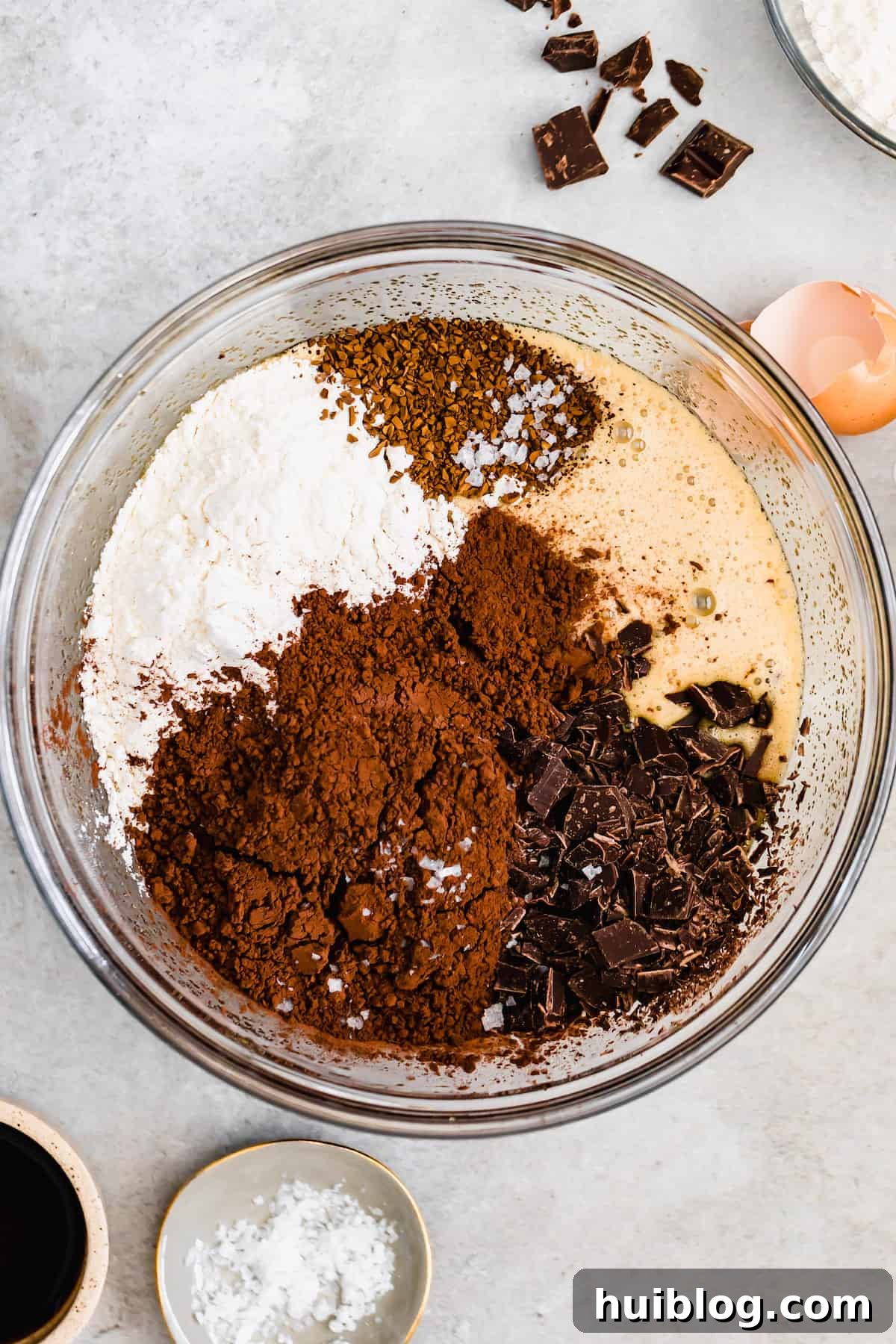 Decadent Homemade Fudge Brownies 6 A glass bowl of rich brownie batter with dry ingredients and chopped dark chocolate, ready to be mixed