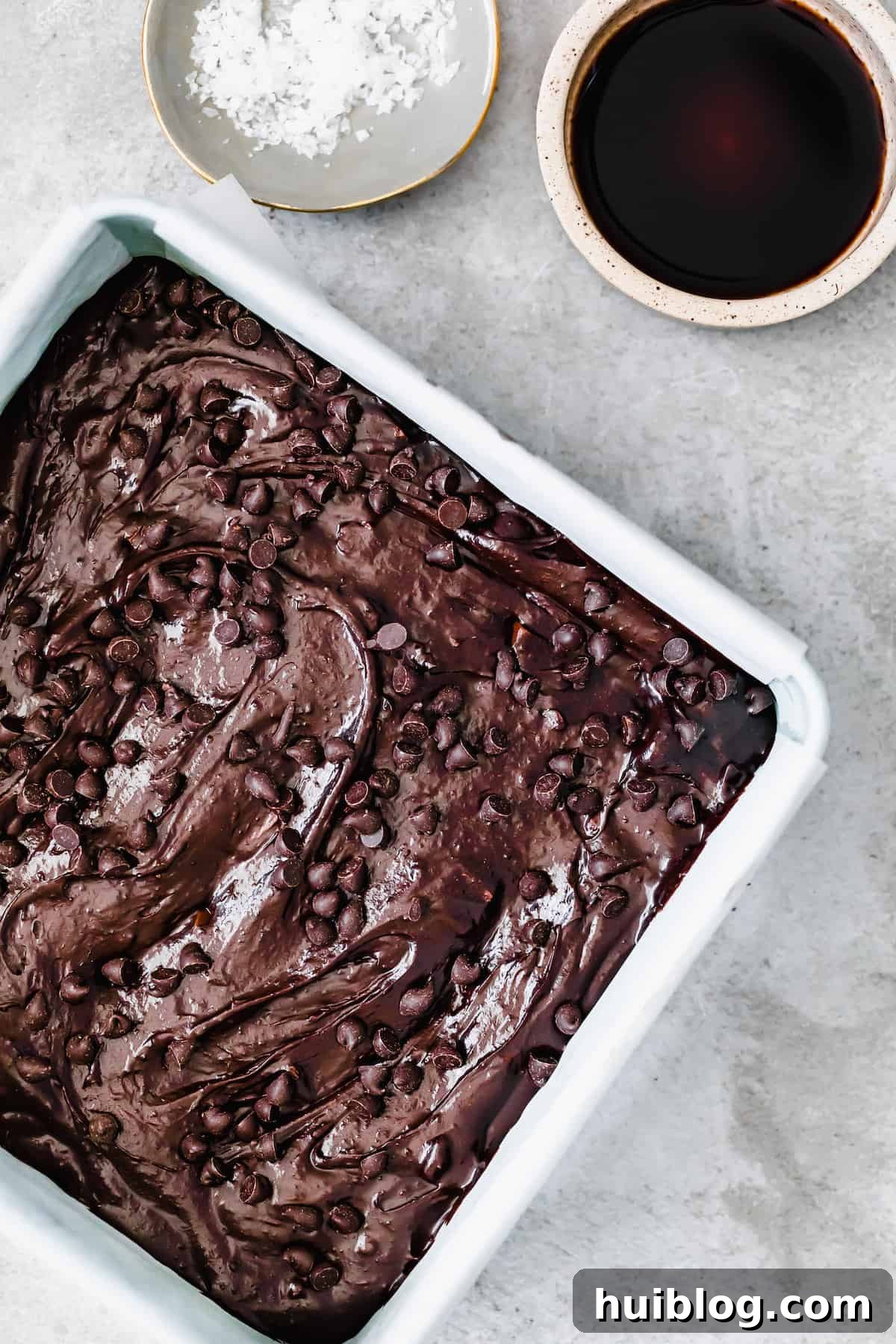 Decadent Homemade Fudge Brownies 7 Unbaked homemade brownies in a pan, topped with a generous layer of milk chocolate chips