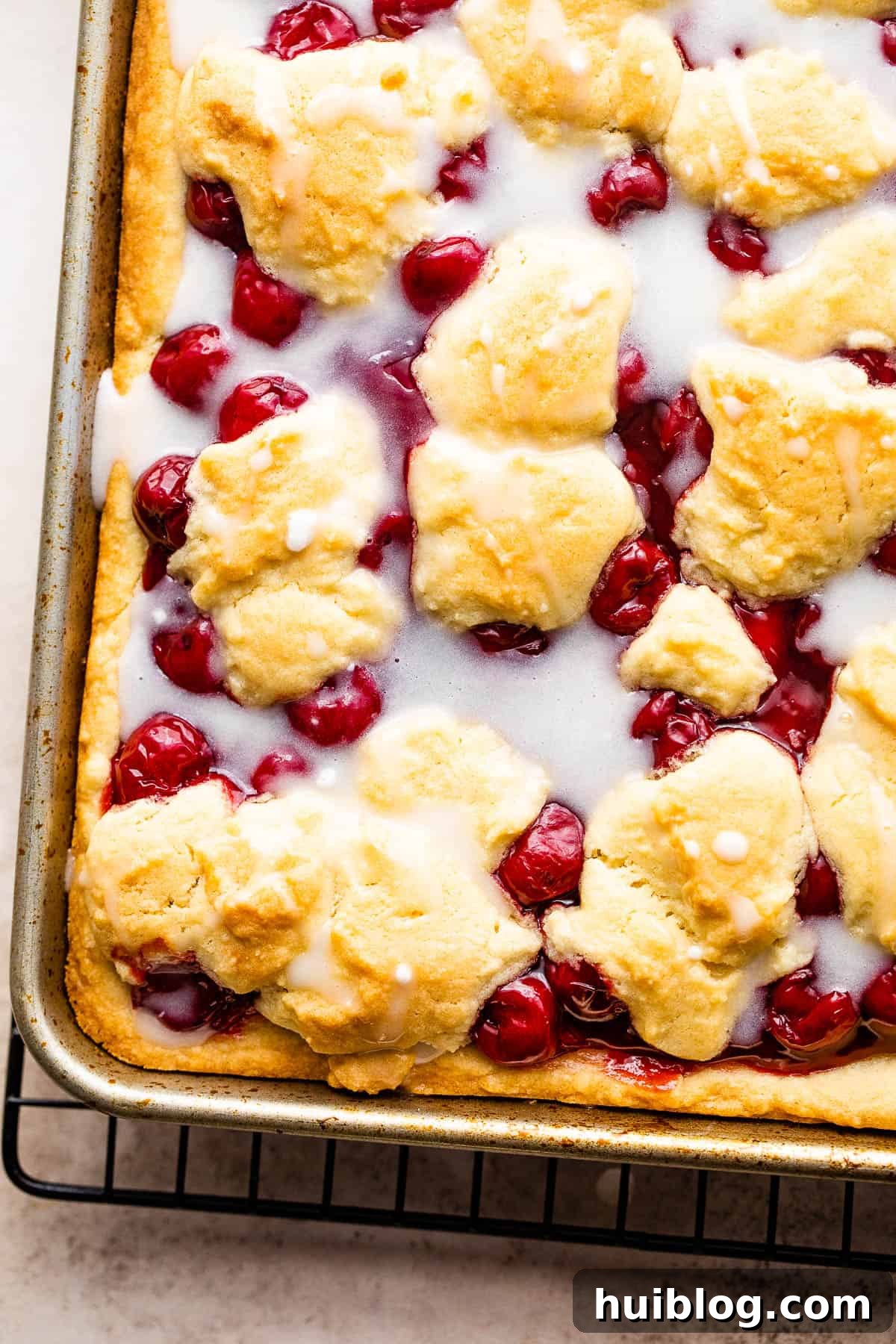 A Pan of Cherry Kuchen Bars Drizzled with Homemade Icing, captured from an appealing angle
