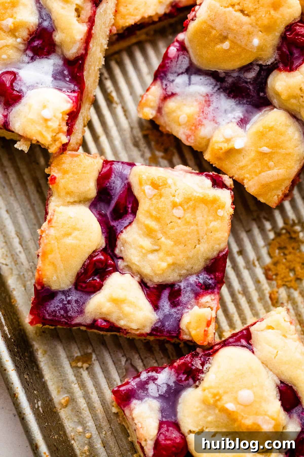 Pan of Cherry Kuchen Bars Topped with Glaze, with one bar removed for serving