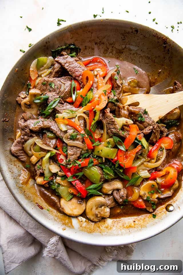 overhead wide shot of a skillet with stir fried beef and vegetables
