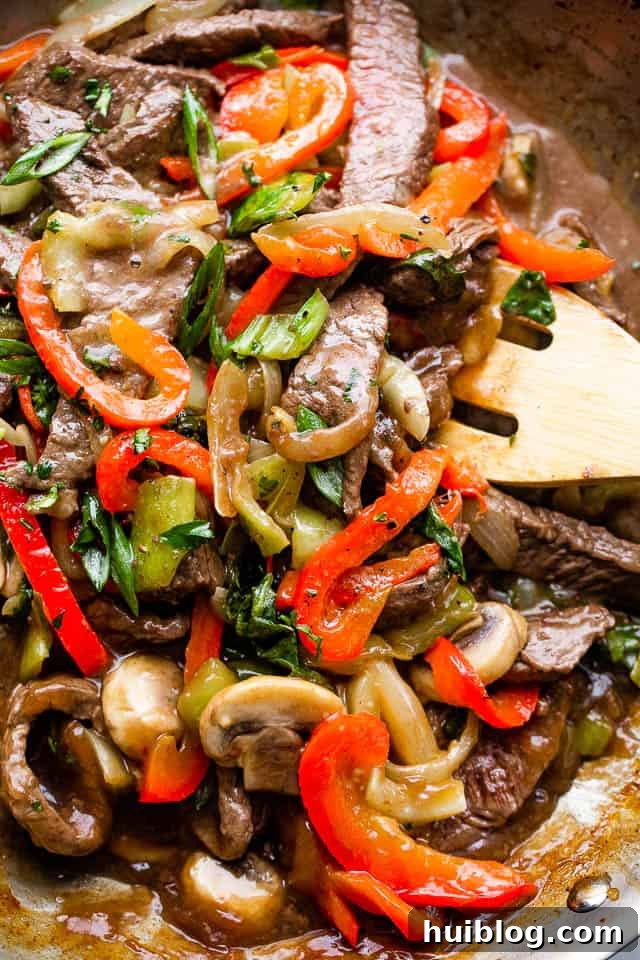 stirring through beef stir fry with vegetables