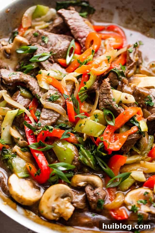 close up photo of beef stir fry with bell peppers, bok choy, mushrooms, and pepper