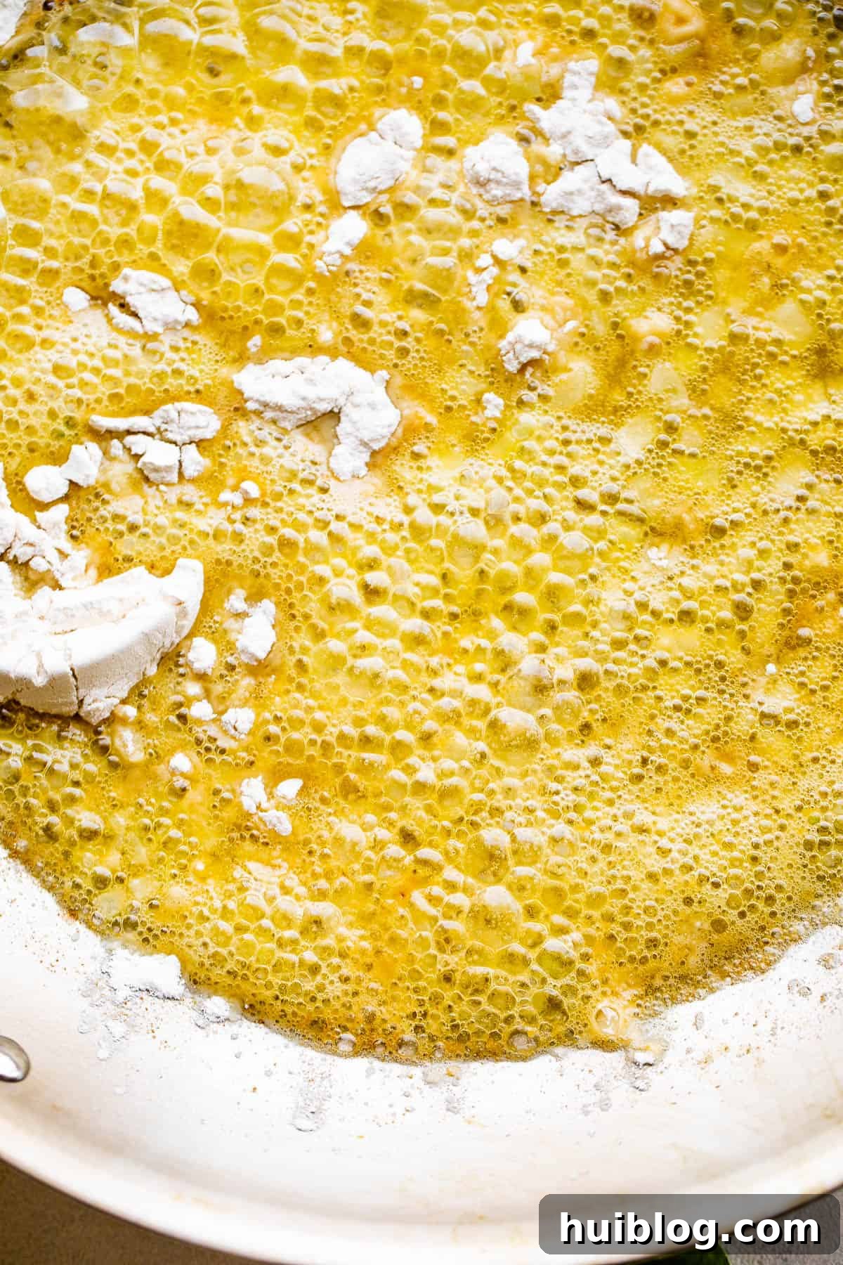 Close-up shot of butter and flour being cooked together in a skillet to form a roux, an essential step for the creamy sauce.
