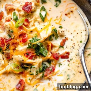 Hearty slow cooker crack chicken soup in a bowl, garnished with fresh toppings.