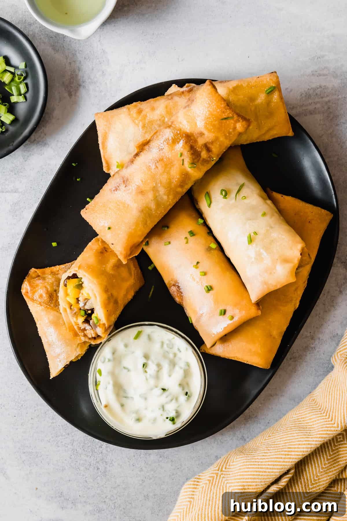Cheesecake Factory Inspired Tex-Mex Egg Rolls 11 Homemade Egg Rolls on a Black Plate with a Container of Dipping Sauce