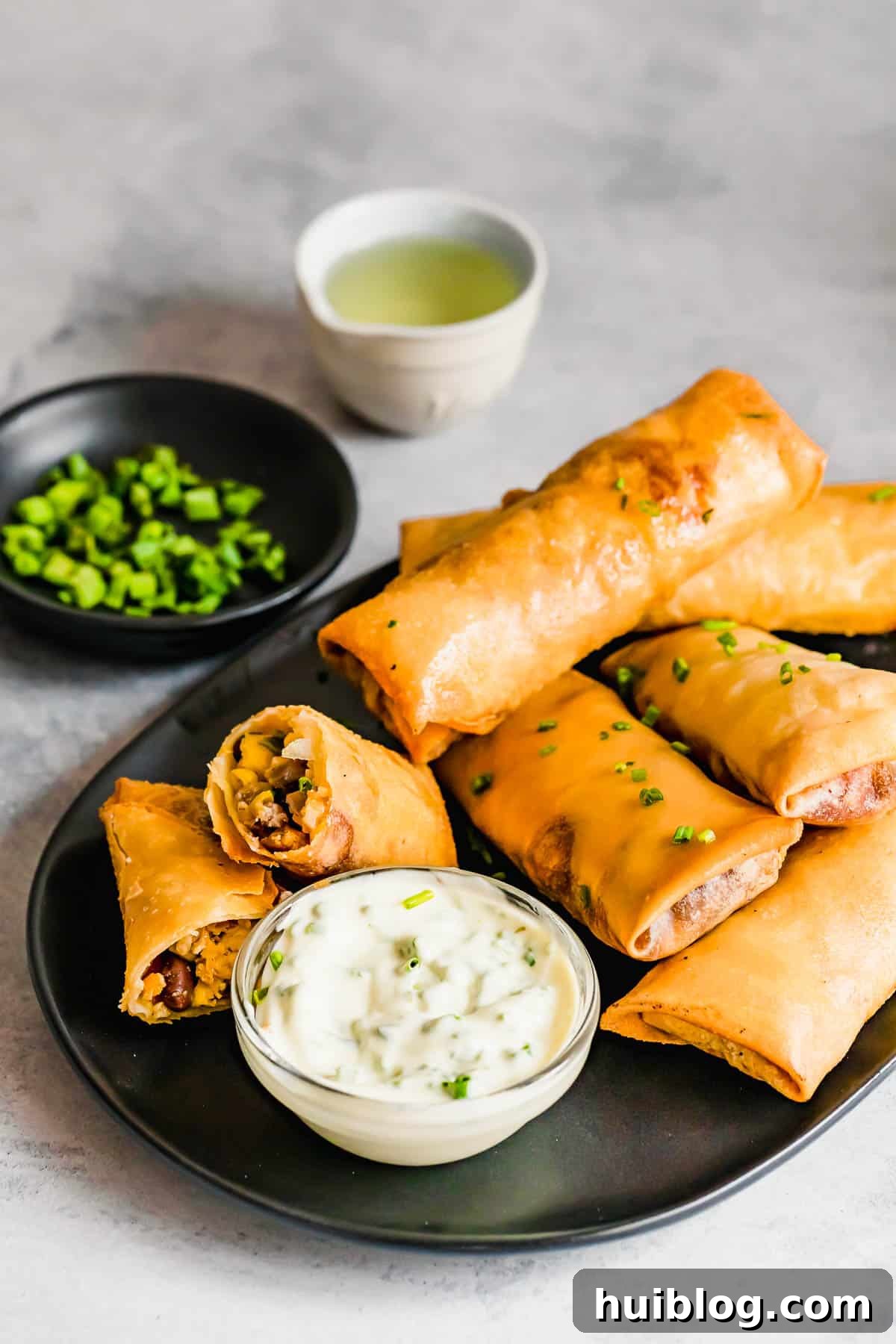 Cheesecake Factory Inspired Tex-Mex Egg Rolls 13 A Plate of Golden Brown Egg Rolls with a Glass Dish of Dipping Sauce