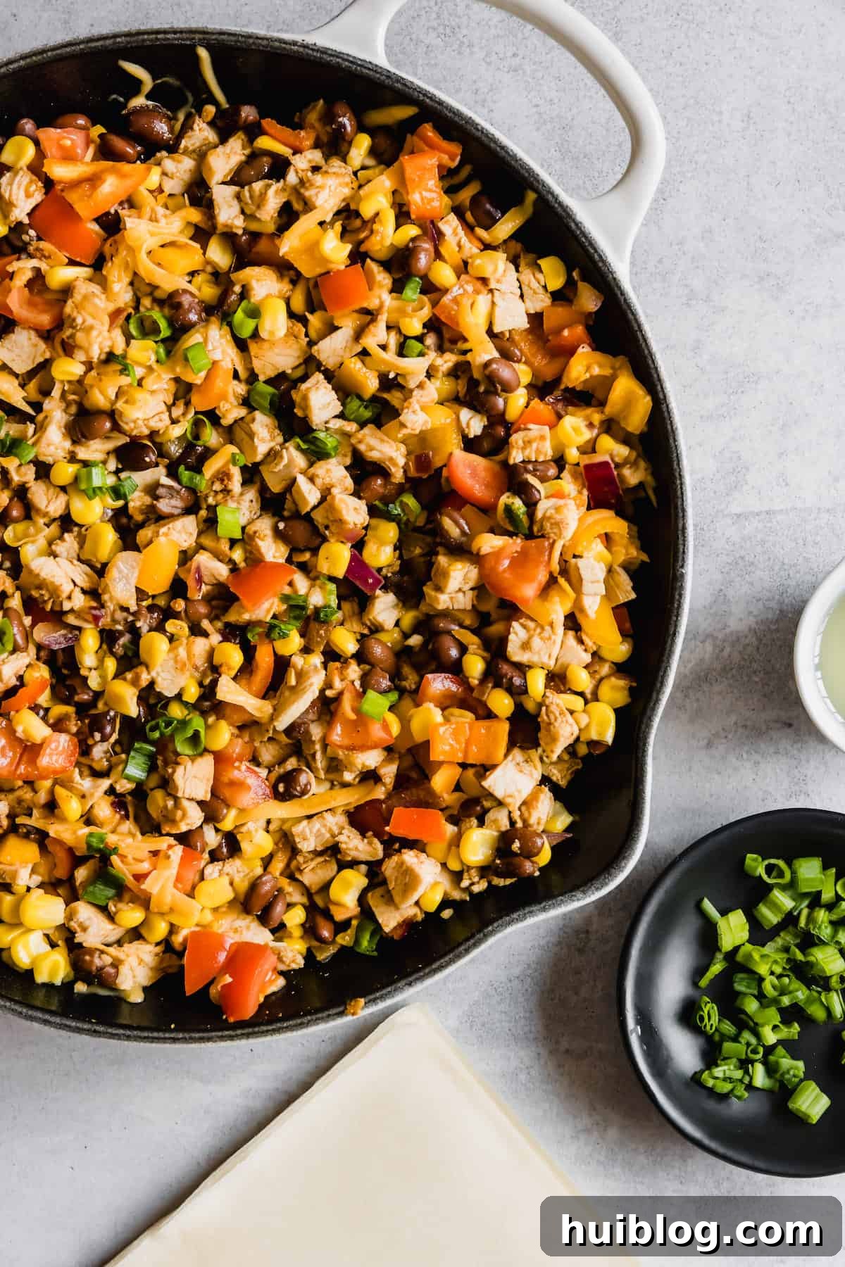 Cheesecake Factory Inspired Tex-Mex Egg Rolls 6 A Metal Skillet Full of the Rich Chicken and Veggie Egg Roll Filling