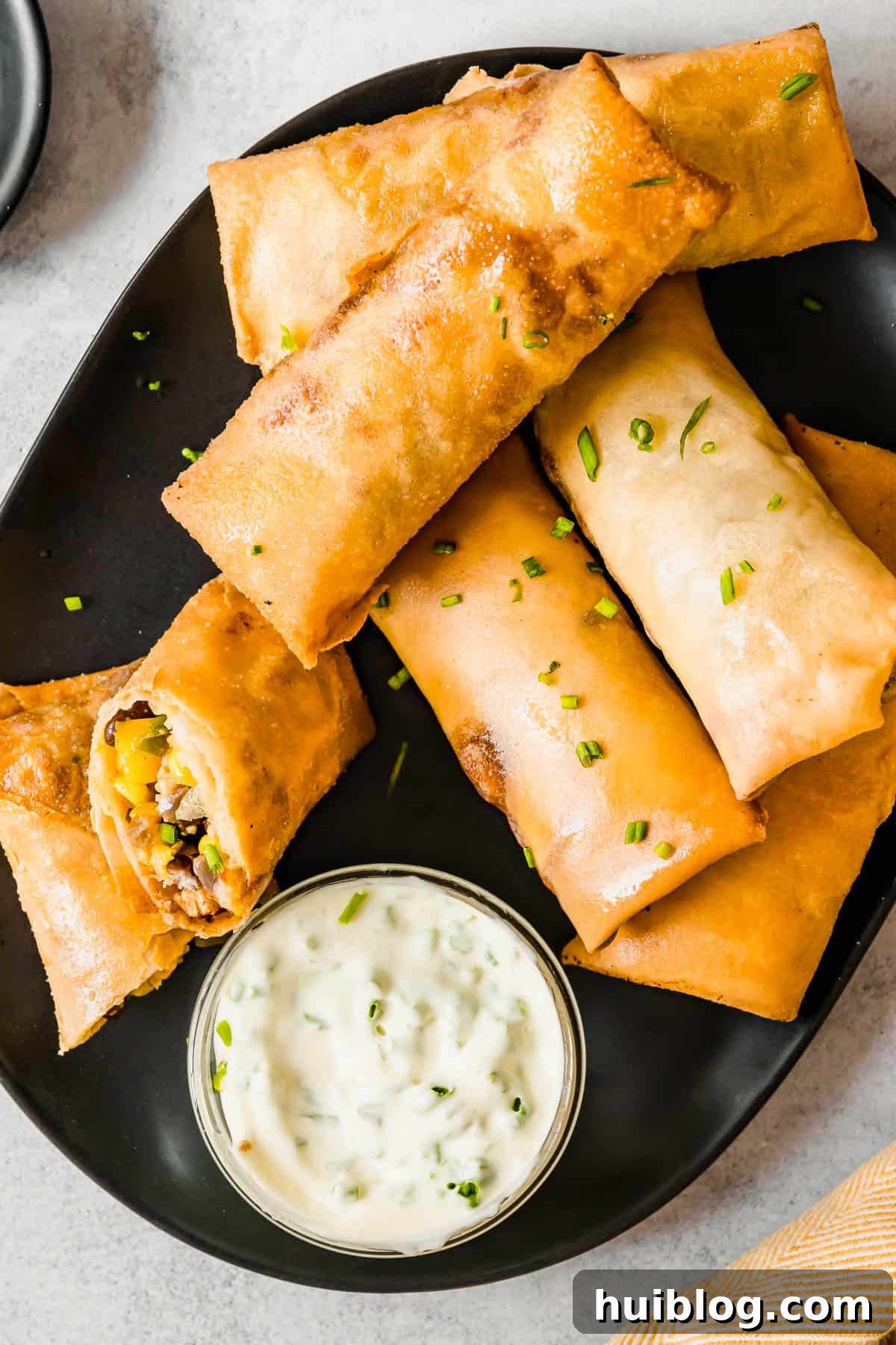 Cheesecake Factory Inspired Tex-Mex Egg Rolls 10 A Plate of Freshly Fried Egg Rolls with a Glass Dish of Dipping Sauce on the Side