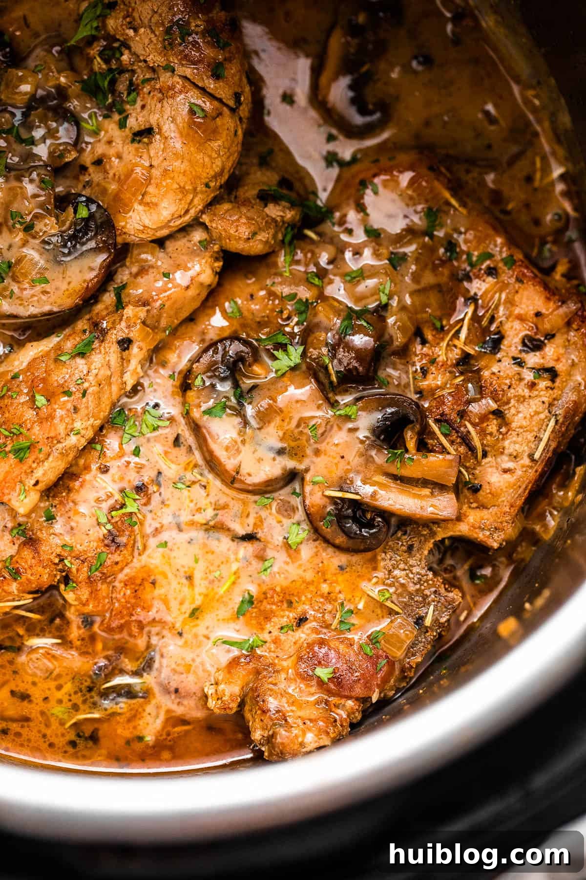 Effortless Instant Pot Pork Chops 2 close up shot of pork chops in the instant pot topped with mushroom gravy sauce