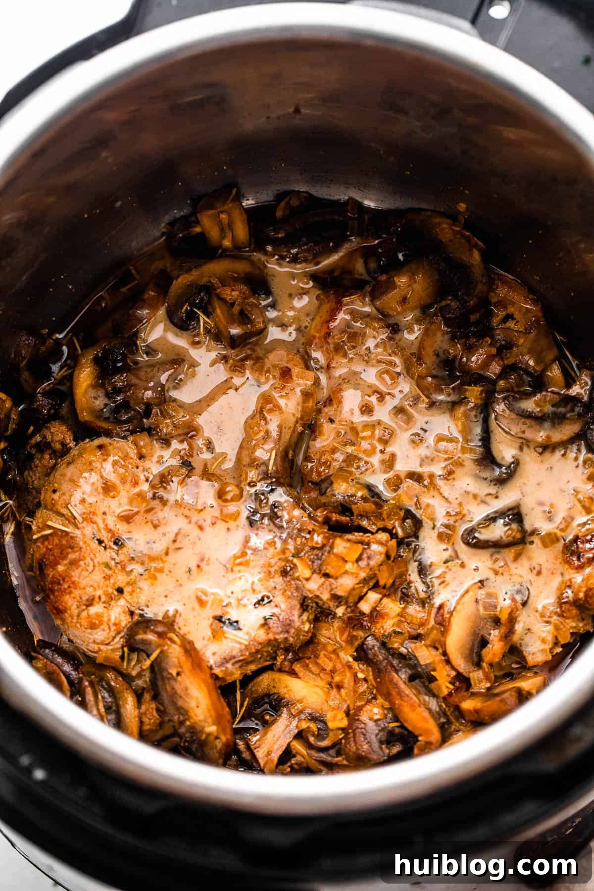 Effortless Instant Pot Pork Chops 5 overhead shot of two pork chops in the instant pot topped with mushroom gravy sauce