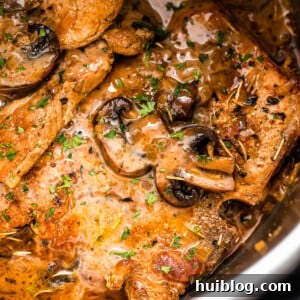 Effortless Instant Pot Pork Chops 7 close up shot of pork chops in the instant pot topped with mushroom gravy sauce