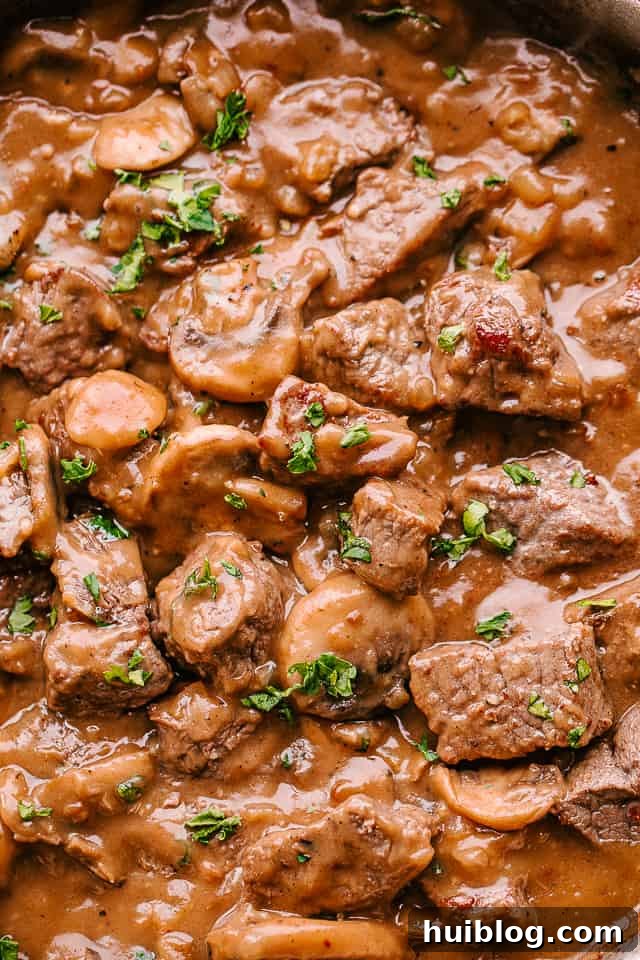 Close-up image of beef tips in mushroom gravy, showcasing the rich texture of the sauce and the browned beef.
