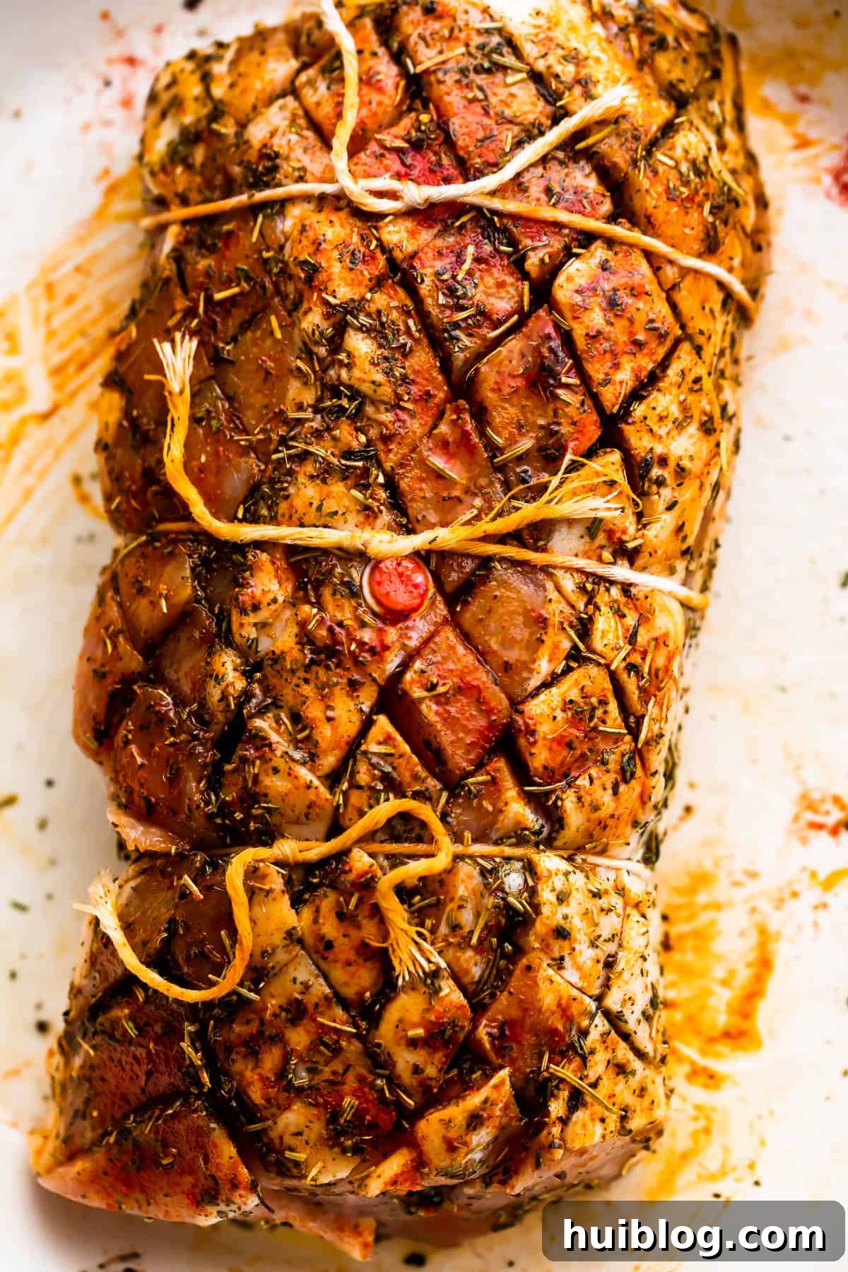 Herb Roasted Pork Loin with Root Vegetables 4 Raw pork loin roast, expertly tied with kitchen twine, ready for seasoning and cooking.