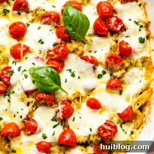 Zesty Caprese Chicken Bake 8 Chicken Caprese Casserole in a white baking dish topped with fresh basil leaves and cherry tomatoes