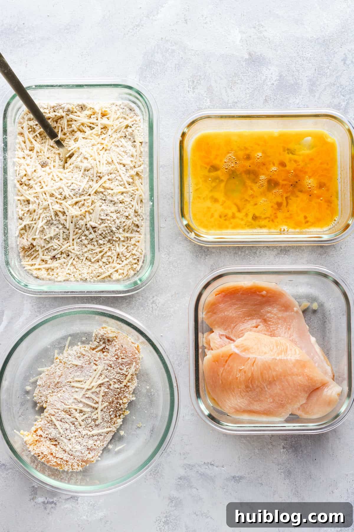 Ultimate Air Fryer Chicken Parmesan 6 Three Pieces of Raw Chicken Beside a Piece of Raw, Coated Chicken and the Breading and Egg Mixtures