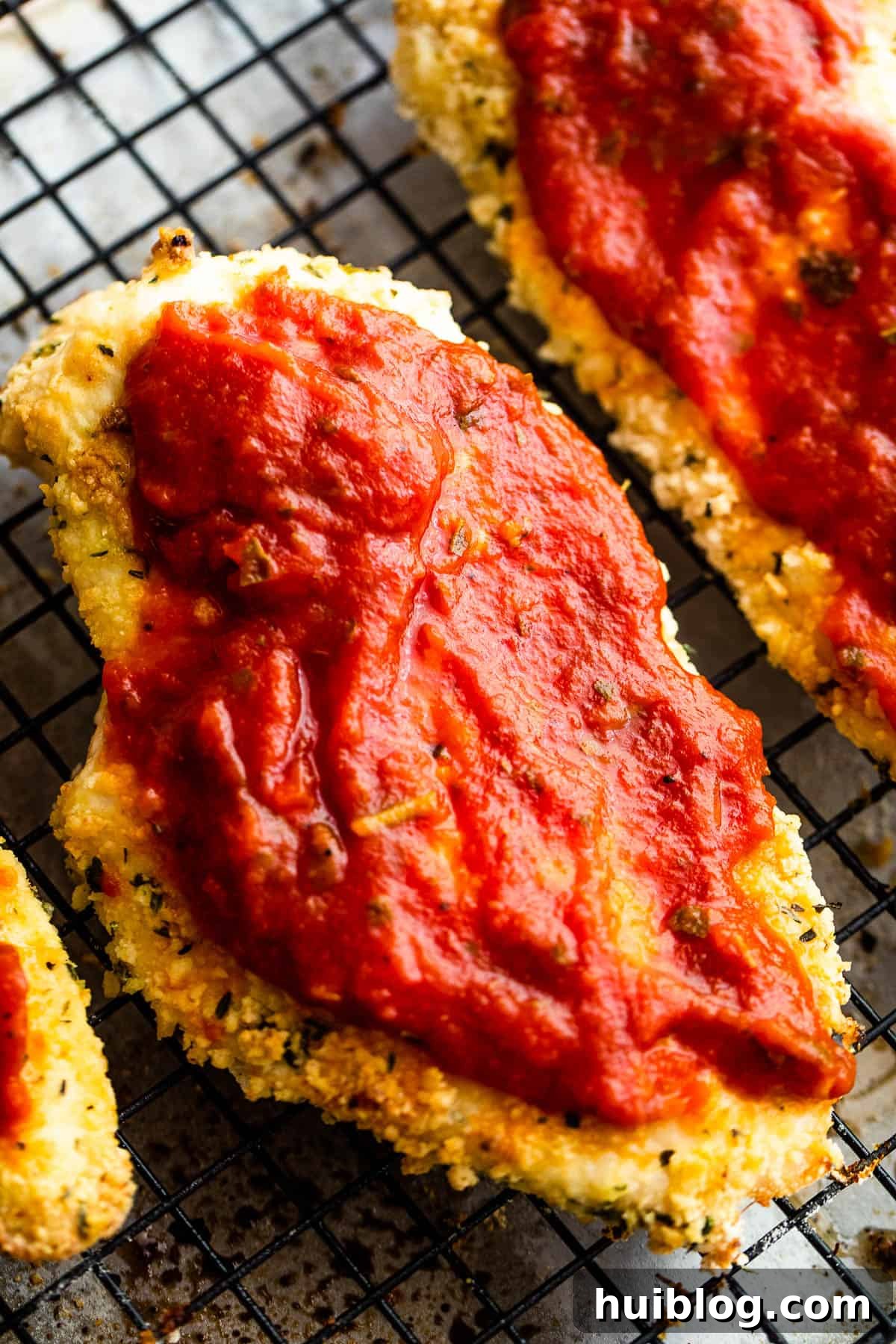 Ultimate Air Fryer Chicken Parmesan 7 Two Pieces of Partially Cooked, Breaded Chicken with Marinara Sauce Spread on Top