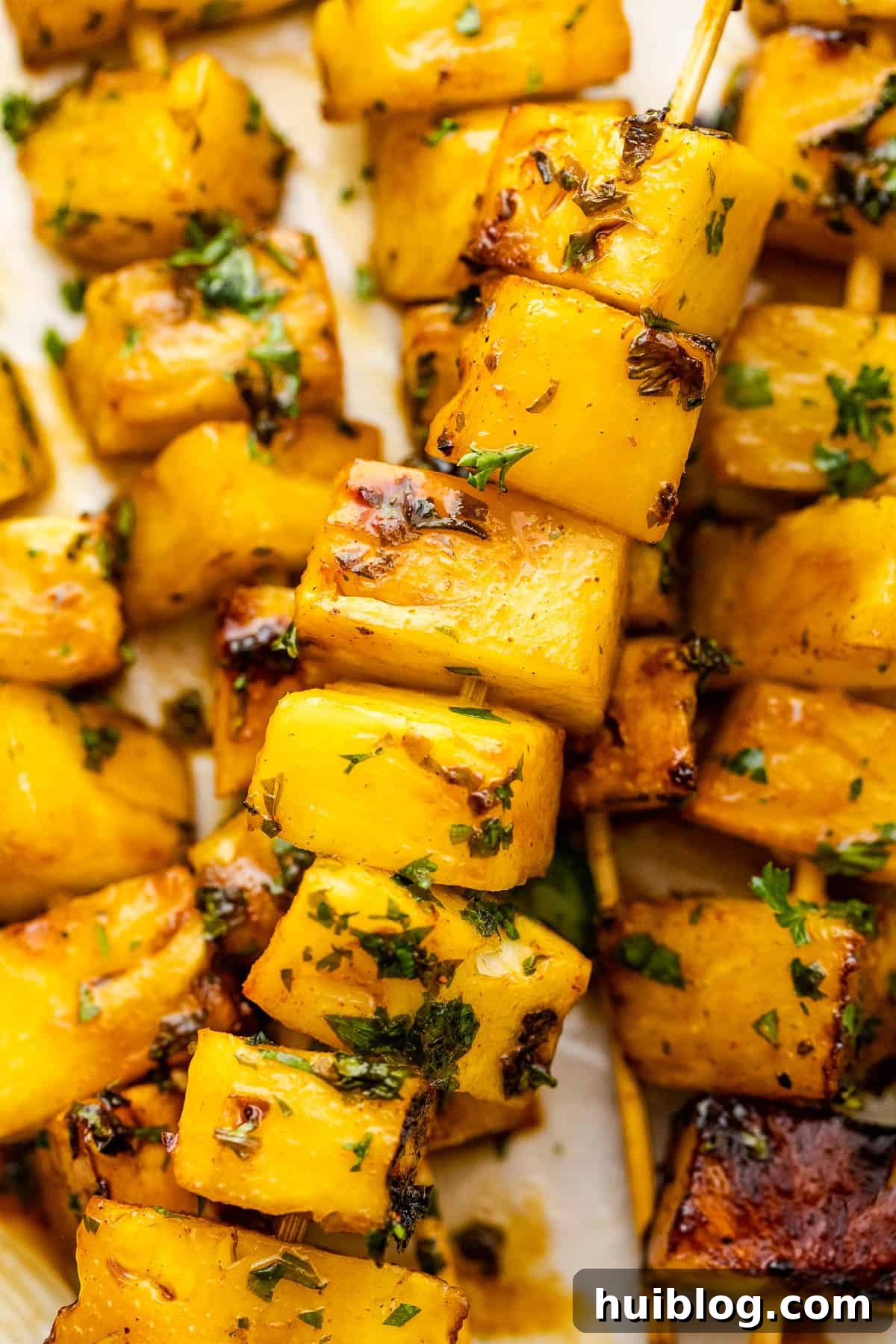 close up shot of grilled pineapple skewers served on a plate