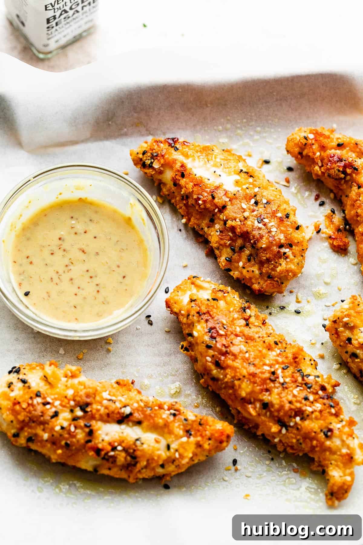 Everything Bagel Crusted Chicken Tenders 3 Everything Bagel Chicken Tenders on a white background served with dipping sauce