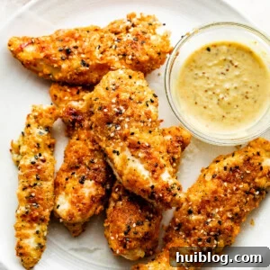 Everything Bagel Crusted Chicken Tenders 8 Everything Bagel Chicken Tenders arranged on a round plate and served with honey mustard dipping sauce