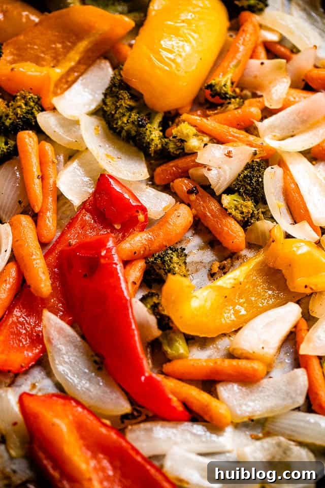 Zesty Grilled Vegetable Medley 4 A vibrant selection of raw vegetables ready for grilling, including strips of red, yellow, and green bell peppers, broccoli florets, and sliced onions.