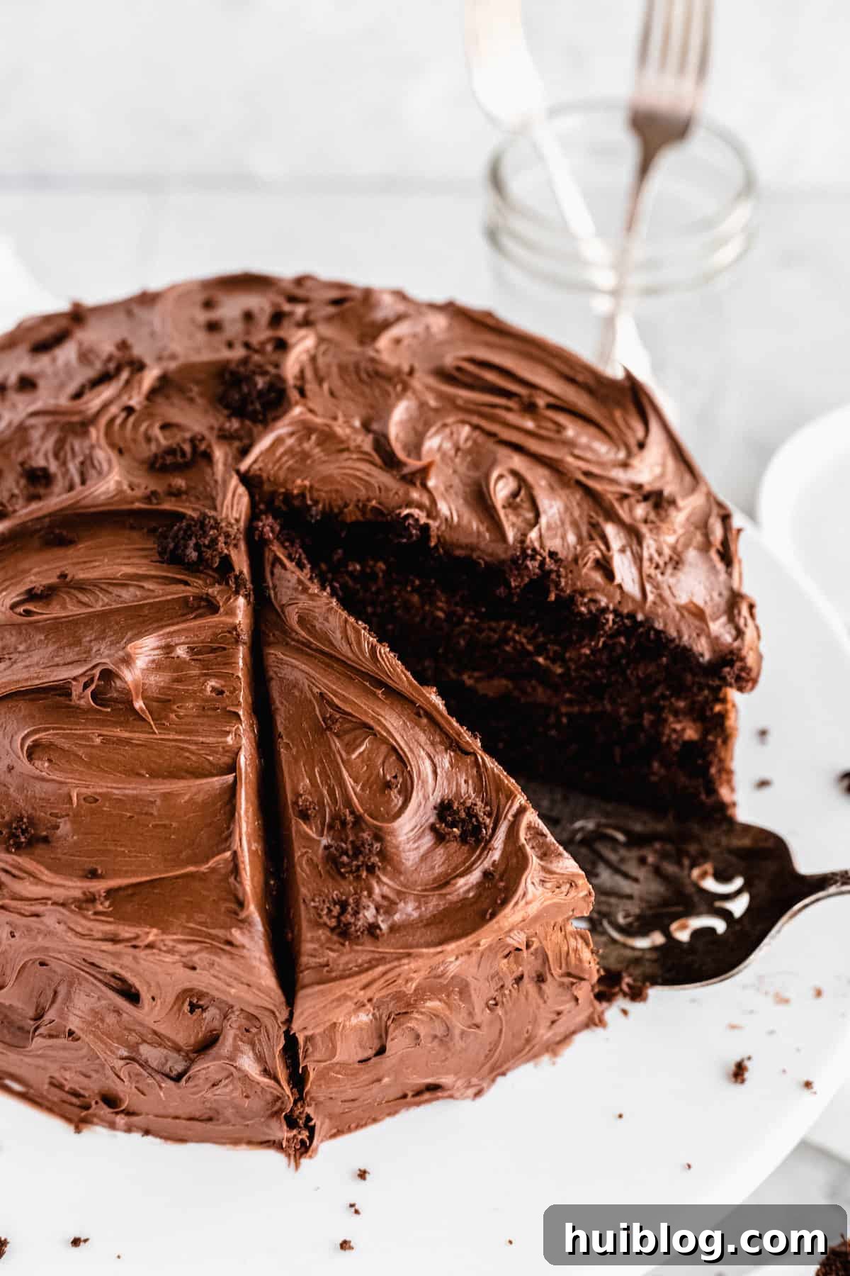 A whole frosted chocolate cake, elegantly presented