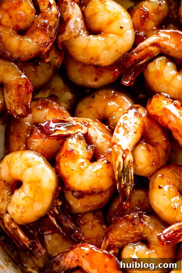 Honey Garlic Shrimp are cooked in the most delicious sauce. A quick, easy shrimp recipe that uses only one skillet, 5 ingredients, and 20 min! Close-up of fresh raw shrimp being prepared for the honey garlic marinade.