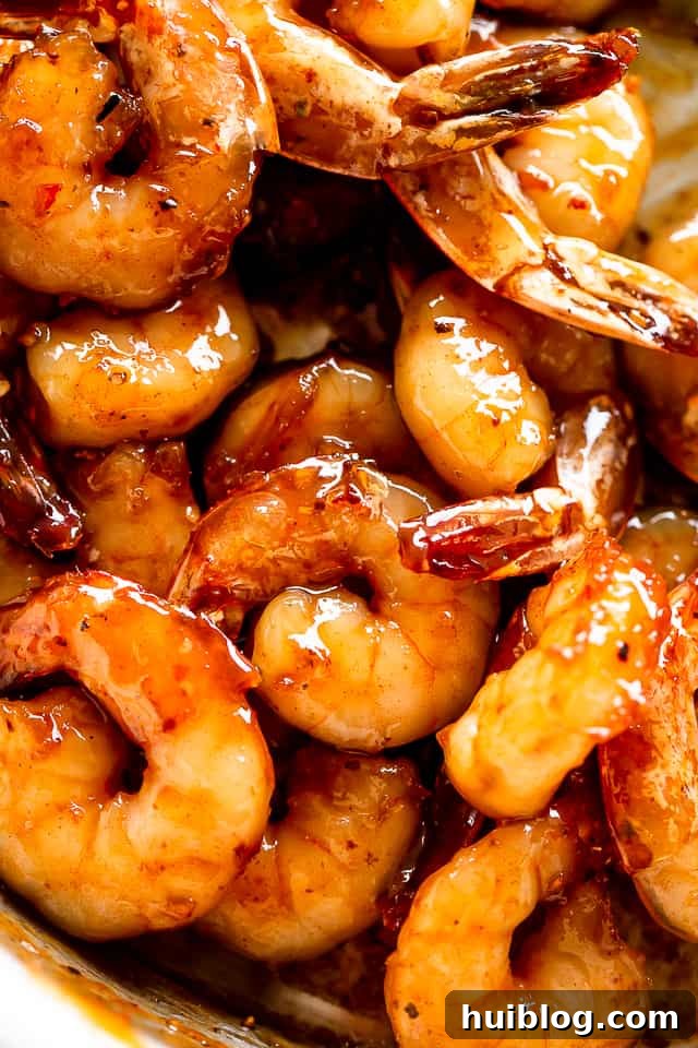 Honey Garlic Shrimp are cooked in the most delicious sauce. A quick, easy shrimp recipe that uses only one skillet, 5 ingredients, and 20 min! A beautifully plated dish of cooked honey garlic shrimp, ready to be served.