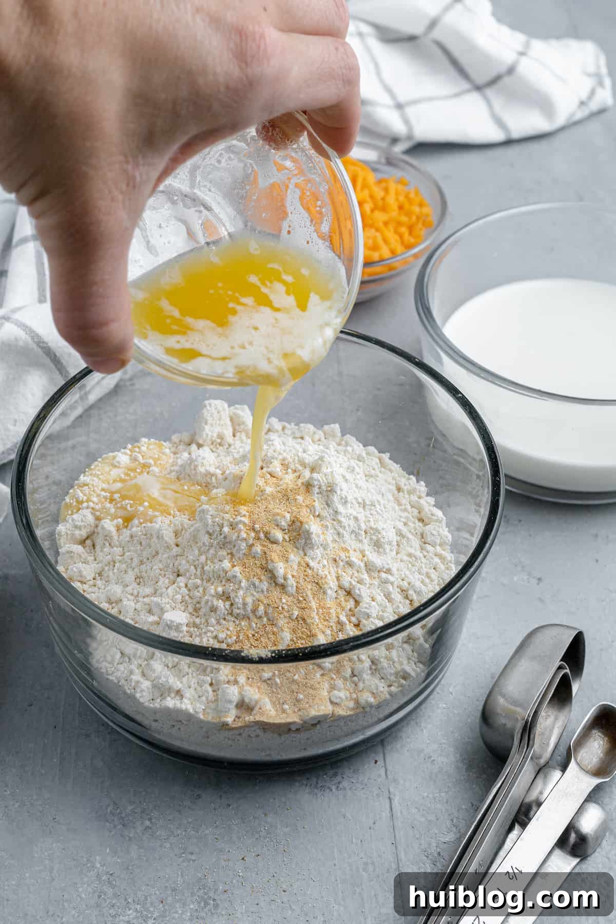 Melted butter being poured over a bowl of Bisquick mix
