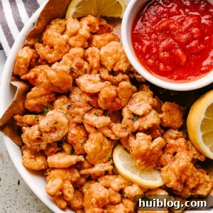 Popcorn shrimp on a plate with lemon and dipping sauce