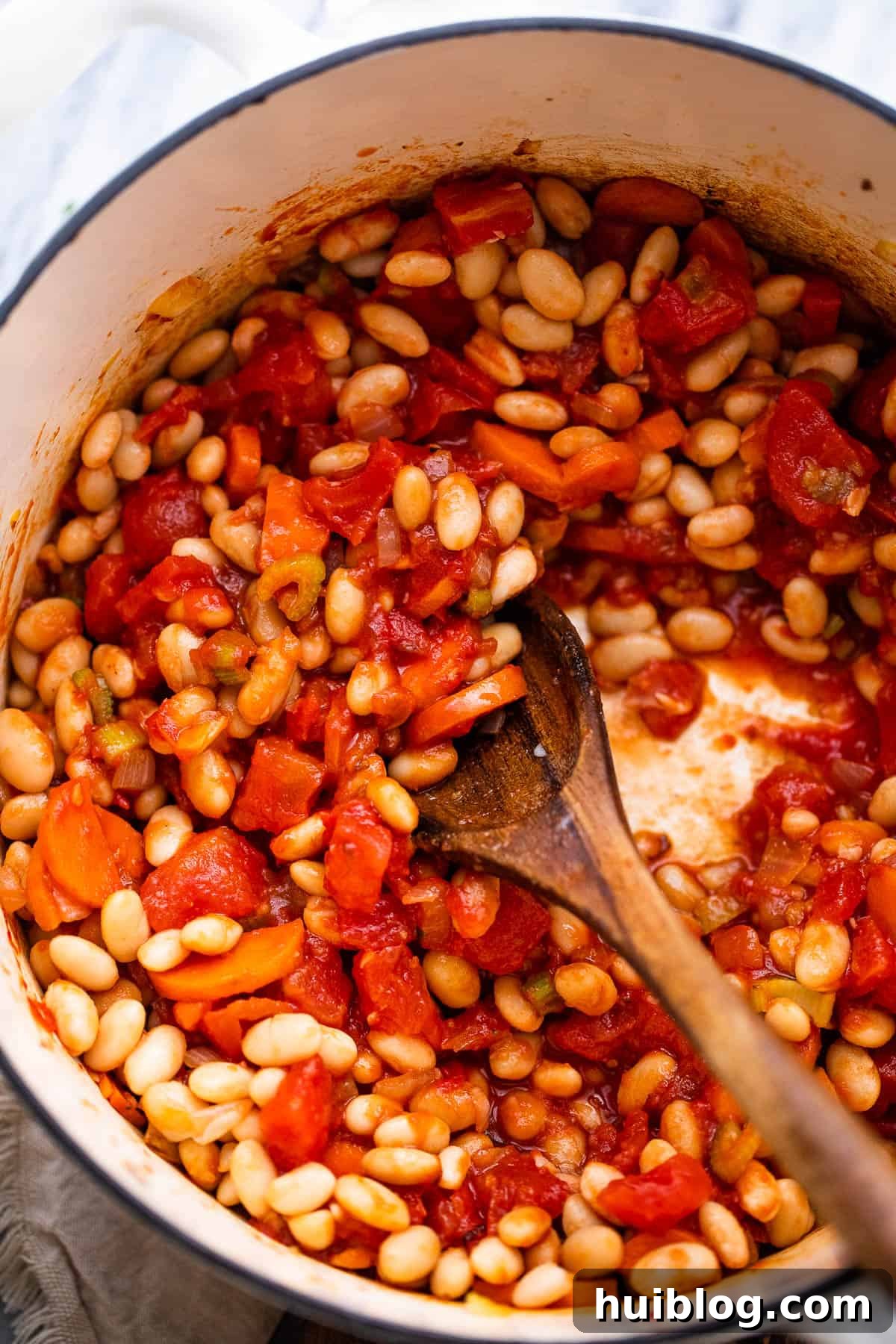 Cooking beans and tomatoes in a Dutch oven for Pasta Fagioli soup.