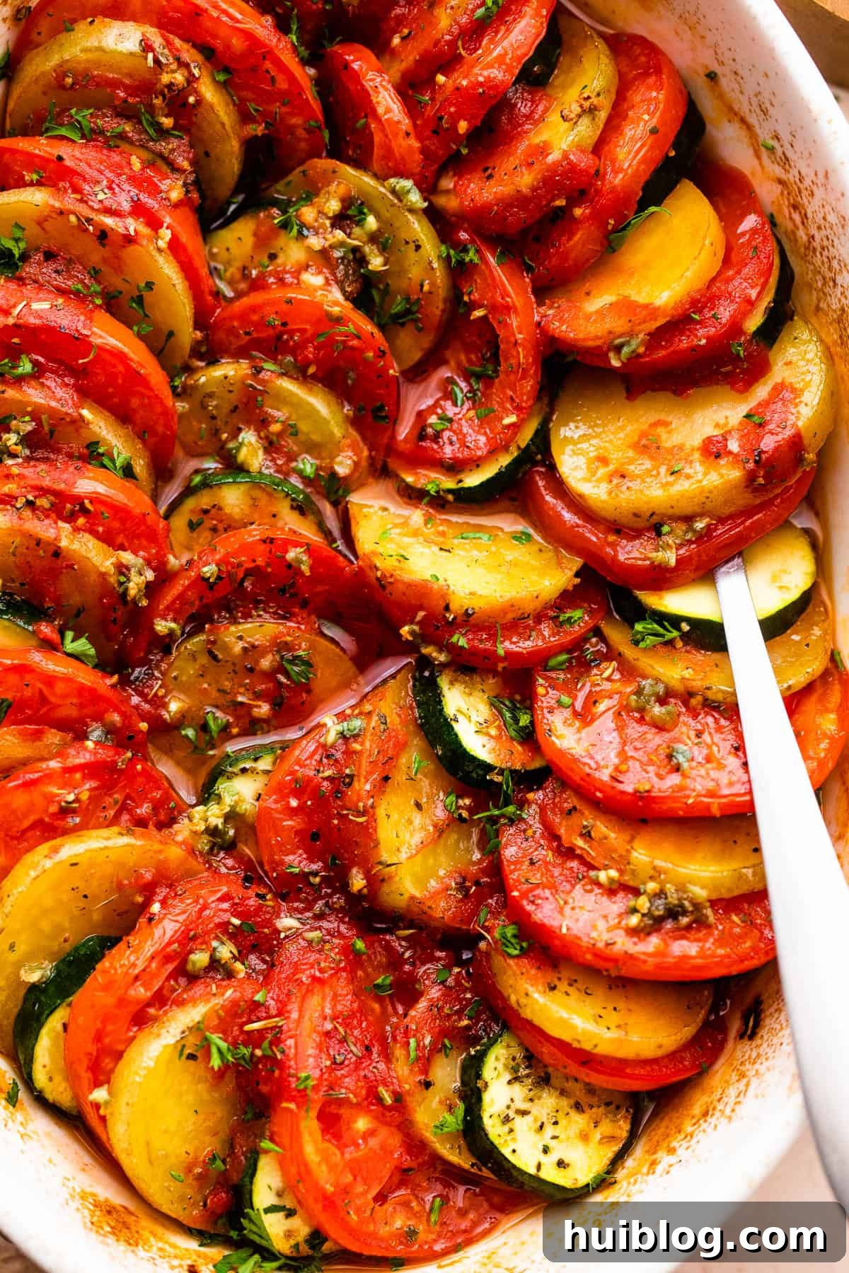 Sun-Kissed Zucchini Tomato Bake 5 Close-up shot of the baked zucchini, tomato, and potato gratin, golden and bubbly with melted Parmesan cheese, garnished with fresh parsley.