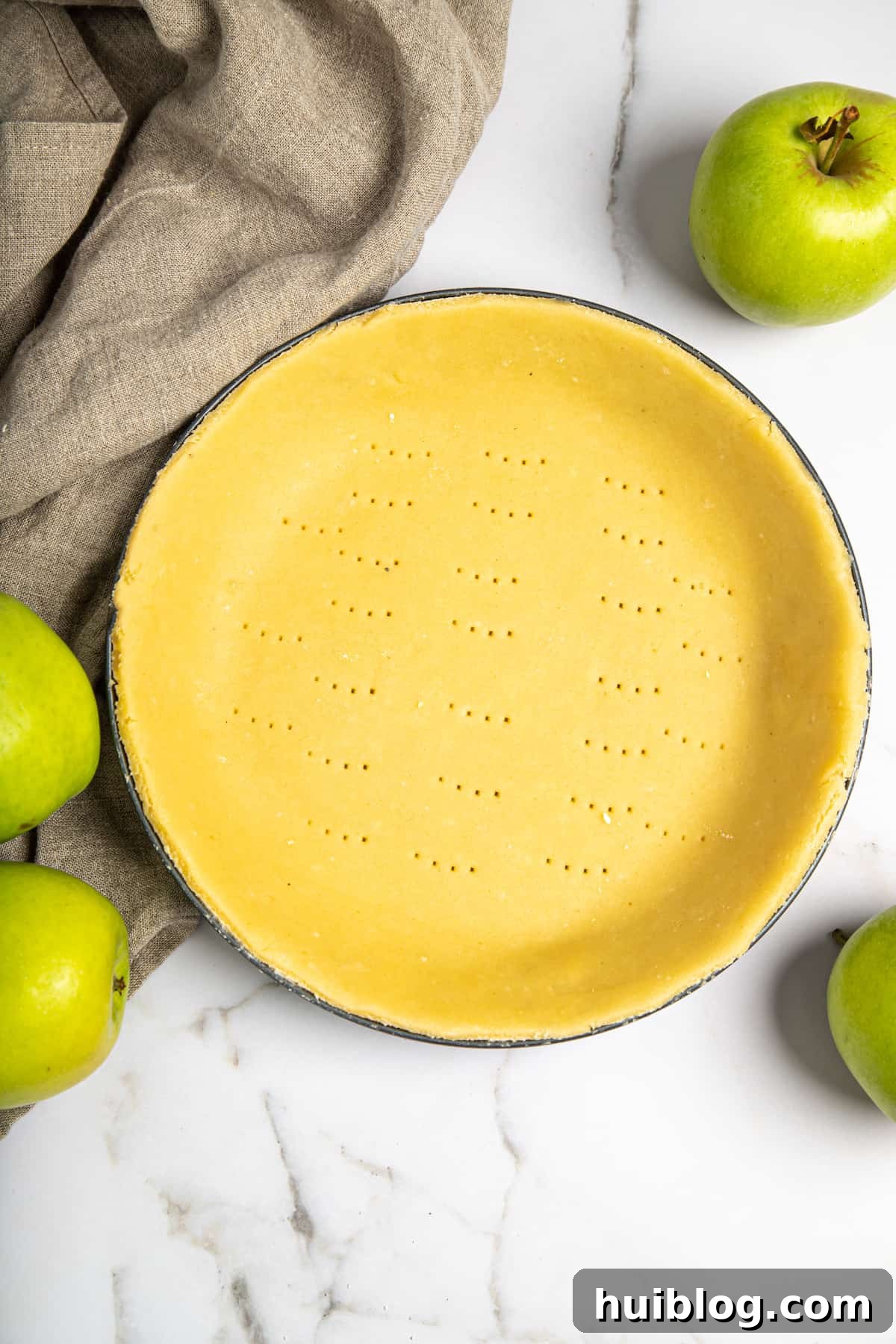 A raw pie shell neatly placed and crimped into a glass pie plate, ready for filling.