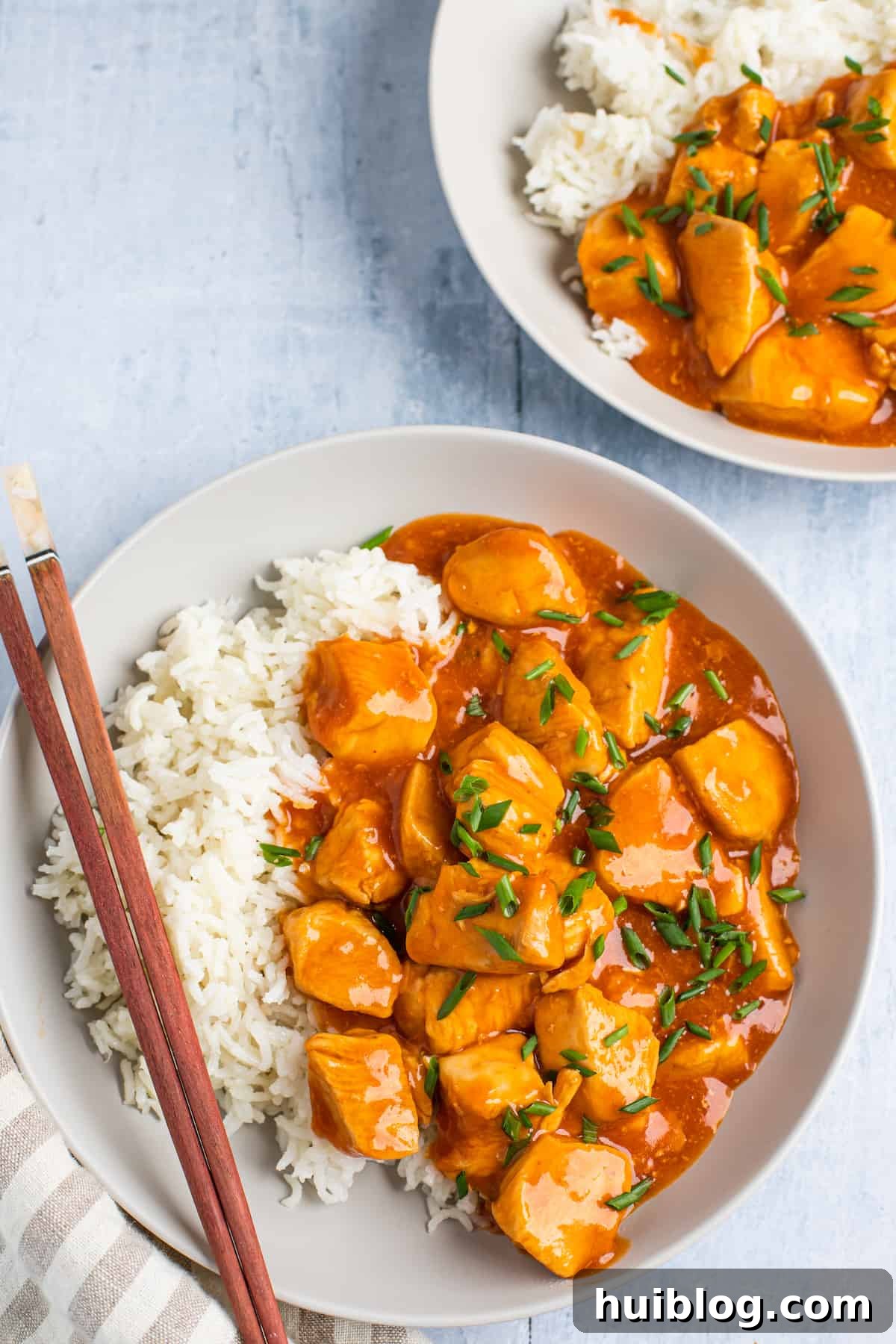 Two plates, each with a serving of Instant Pot orange chicken and white rice, ready for a delicious meal.