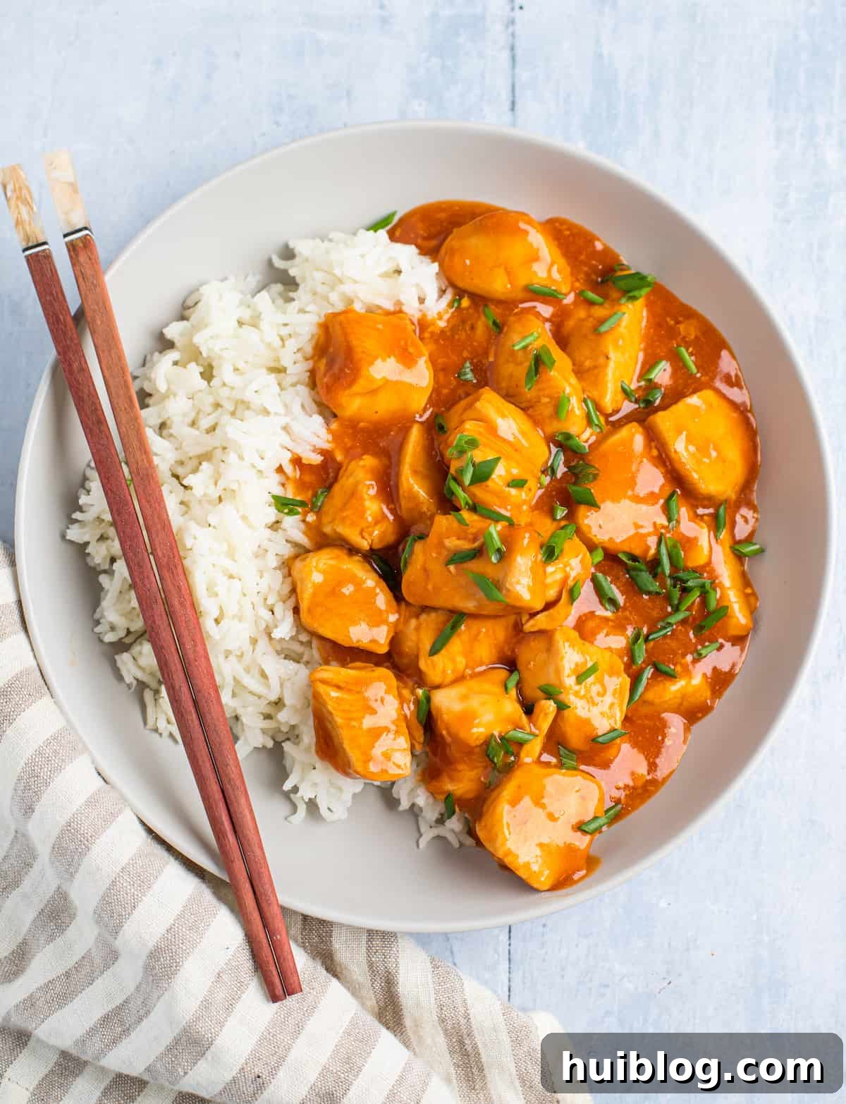 Centered overhead shot of Instant Pot orange chicken served with white rice in a bowl.