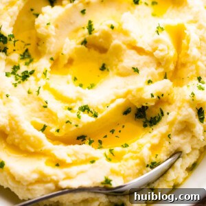 close up overhead shot of creamy mashed potatoes garnished with melted butter and parsley
