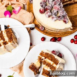 Slices of sugared cranberry layer cake on dessert plates, next to the remaining cake on a cake stand.