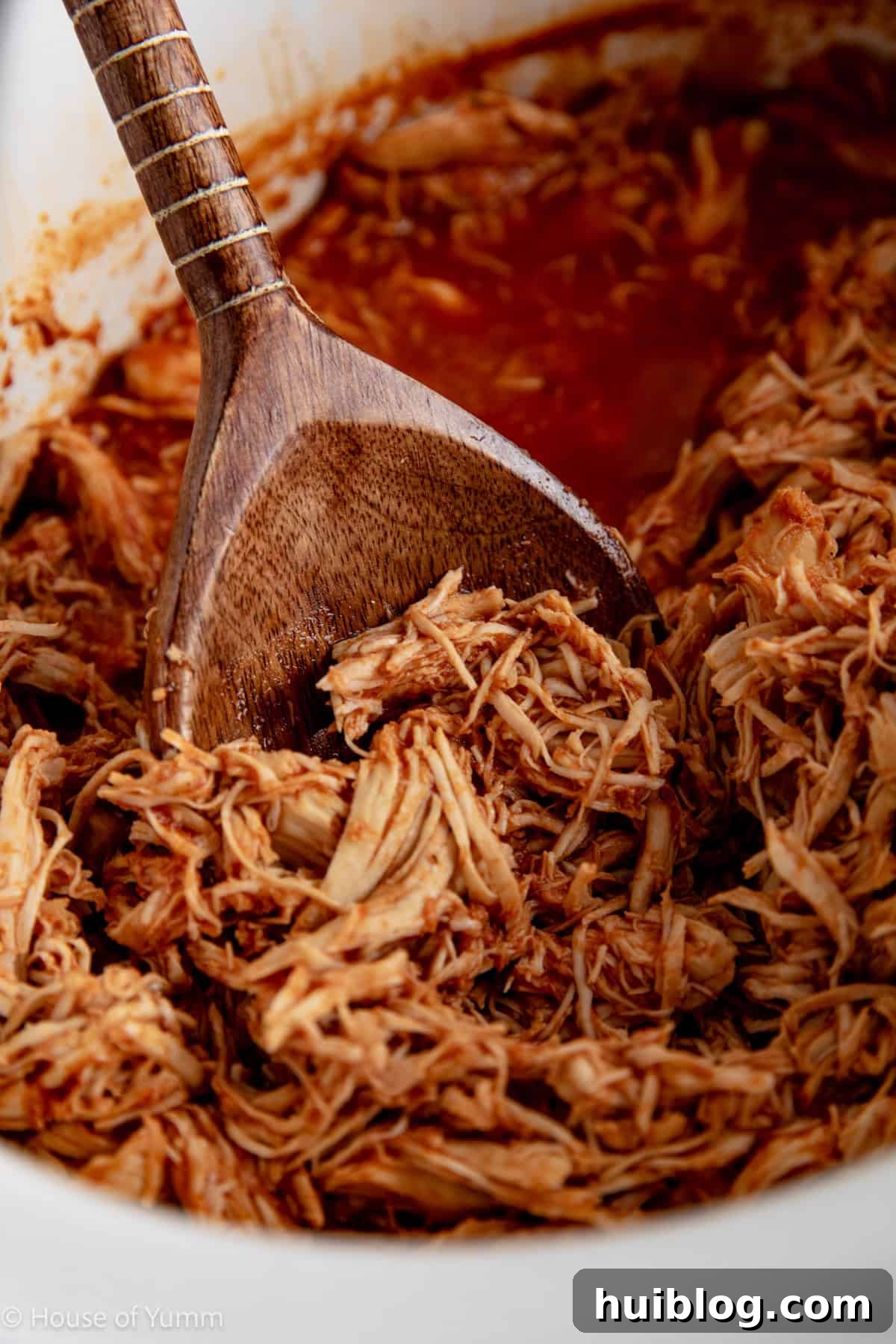 Effortless Slow Cooker BBQ Pulled Chicken 9 Spoon serving up bbq shredded chicken from slow cooker.