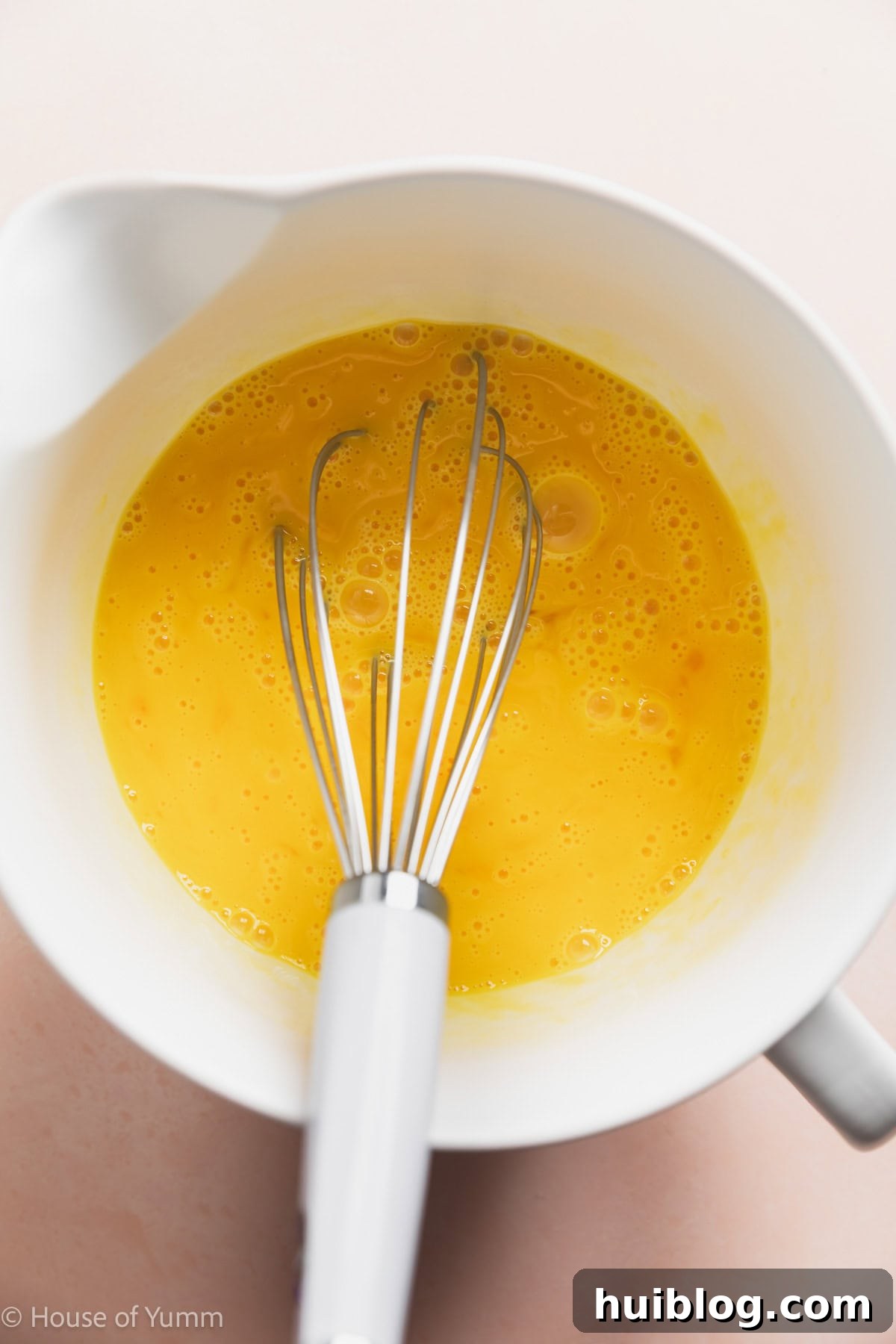 Whisked eggs in a large measuring cup.