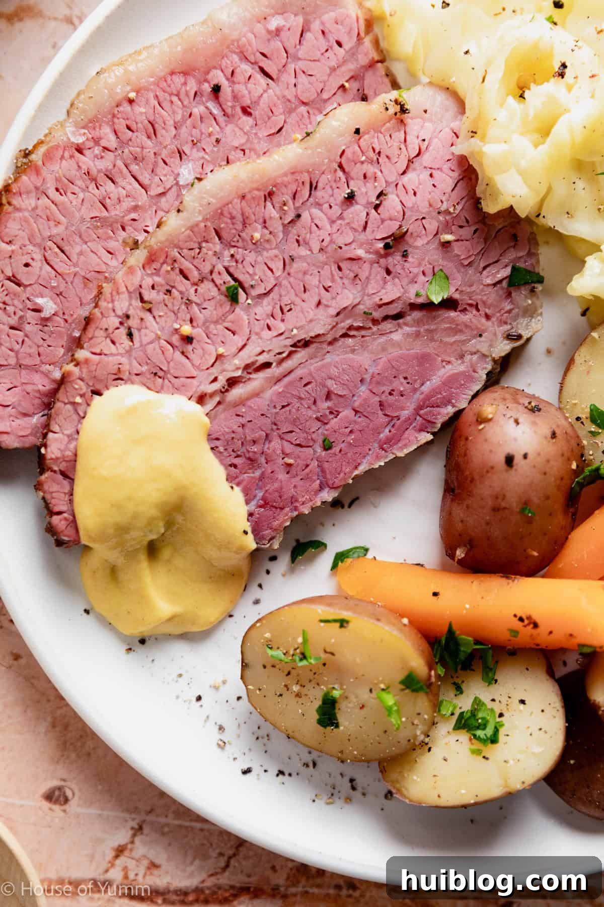 Corned beef slices on a plate with cabbage and vegetables. 