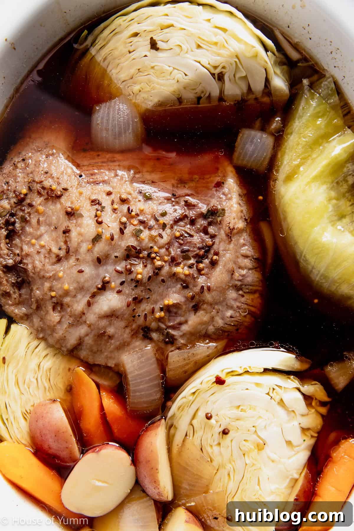 Corned beef cooked in a slow cooker with potatoes, carrots, and cabbage. 
