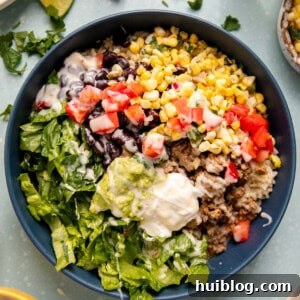 Mexican bowl with rice, beans, corn, and lettuce.