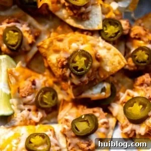 Texas Nachos made with refried beans, cheese and jalapeno on a tray to be served.
